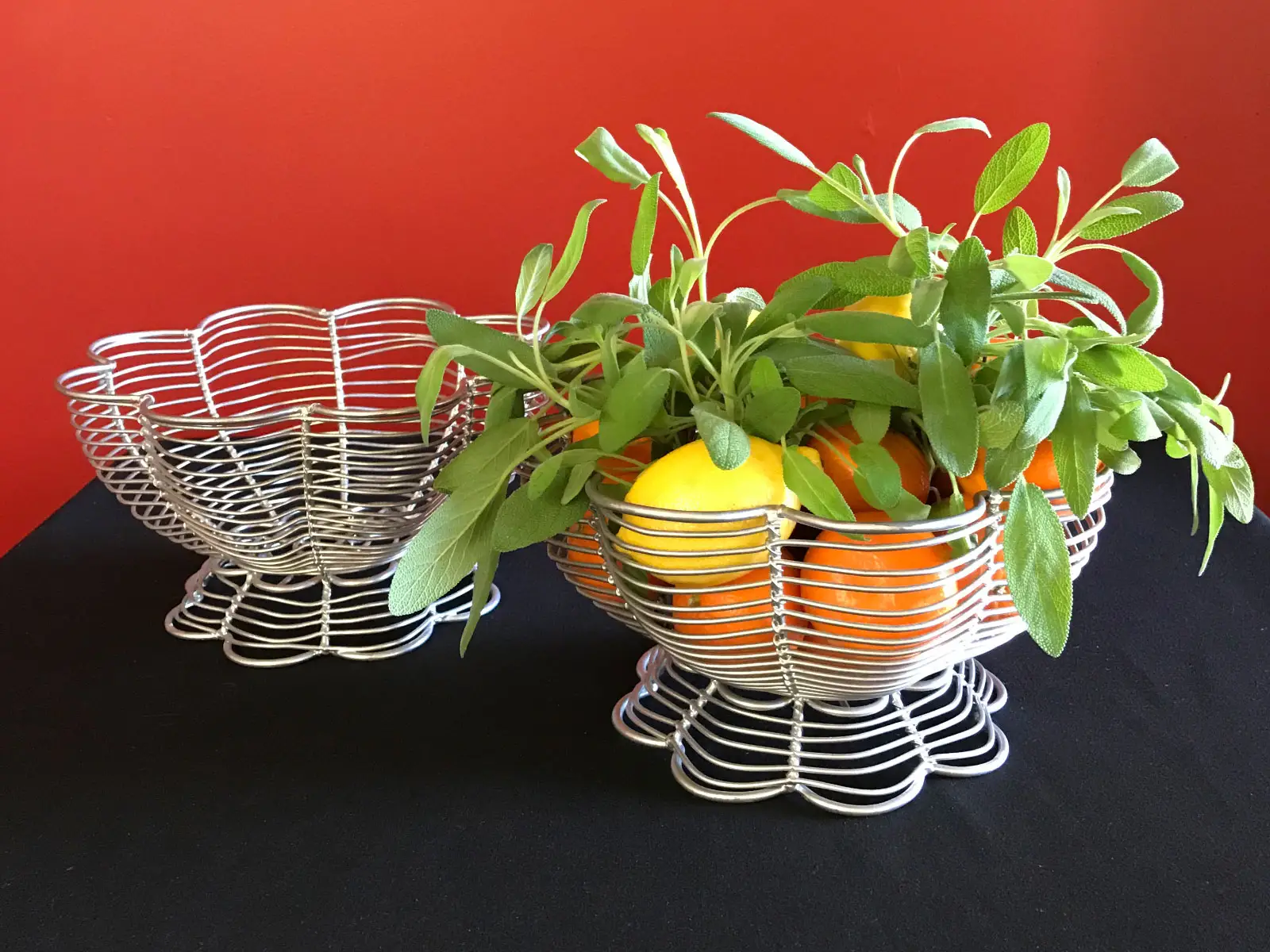 Several wax fruit centerpieces including oranges and lemons in white baskets