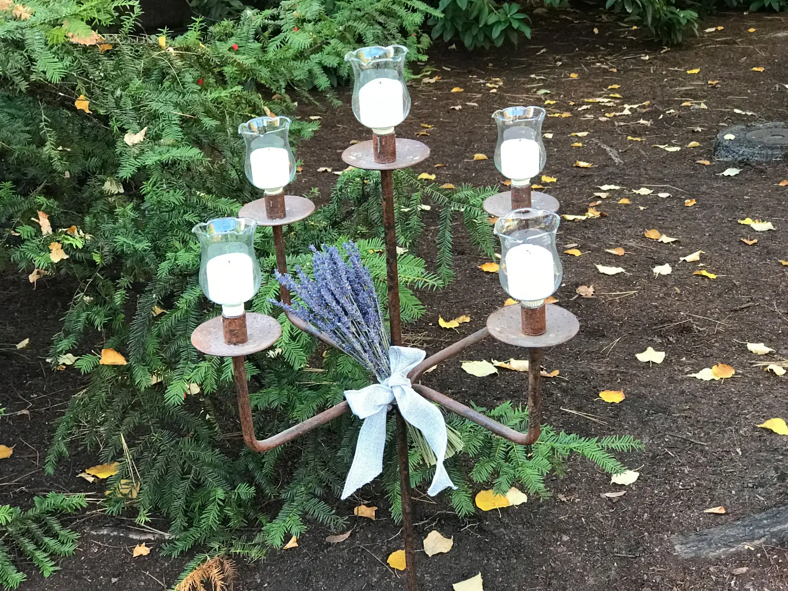 A five-candle metal centerpiece, set in the outside garden of the Oregon City campus