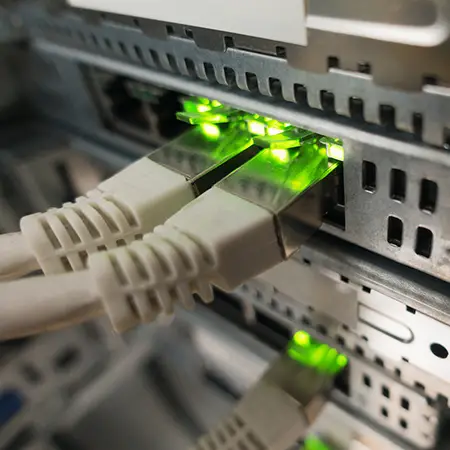 Three ethernet cables are plugged into hardware resulting in green lights at each port.