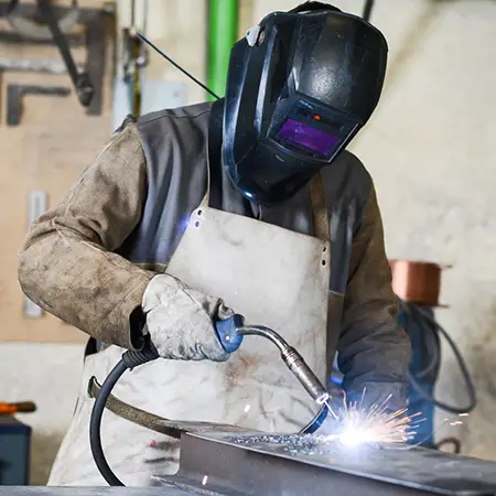 A student doing welding work on a beam.