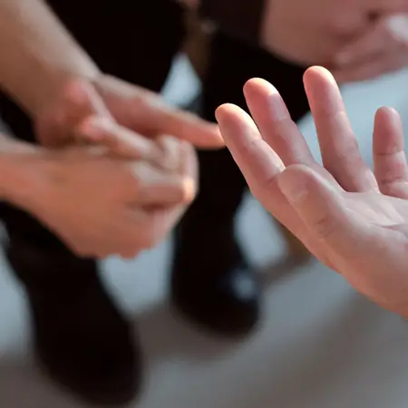 A close-up of open hands as people sit in a circle talking.