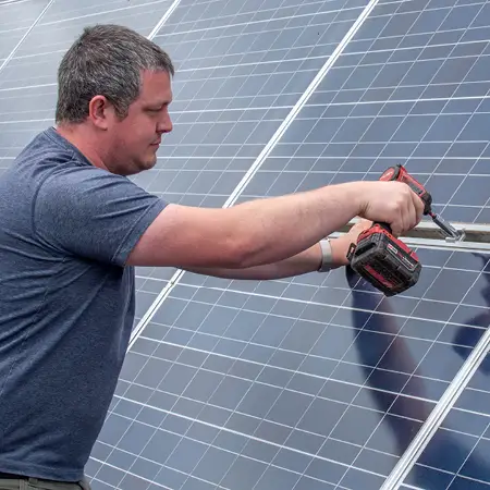 Person using a drill on a solar panel