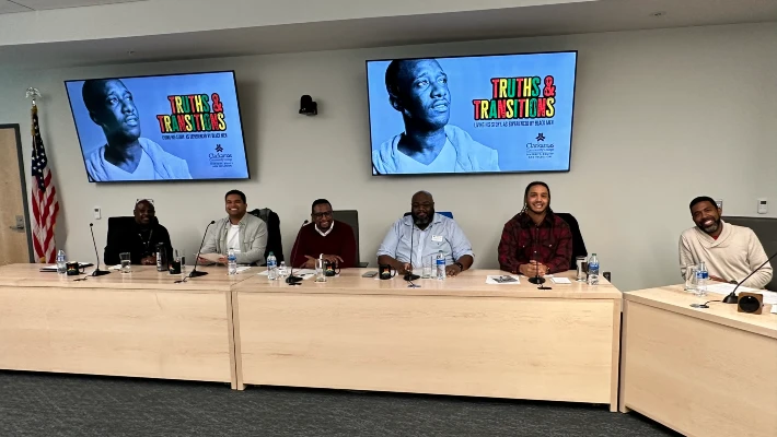 2024 Black Excellence event. Panelists smile in front of screens displaying event title: Truth &Transitions